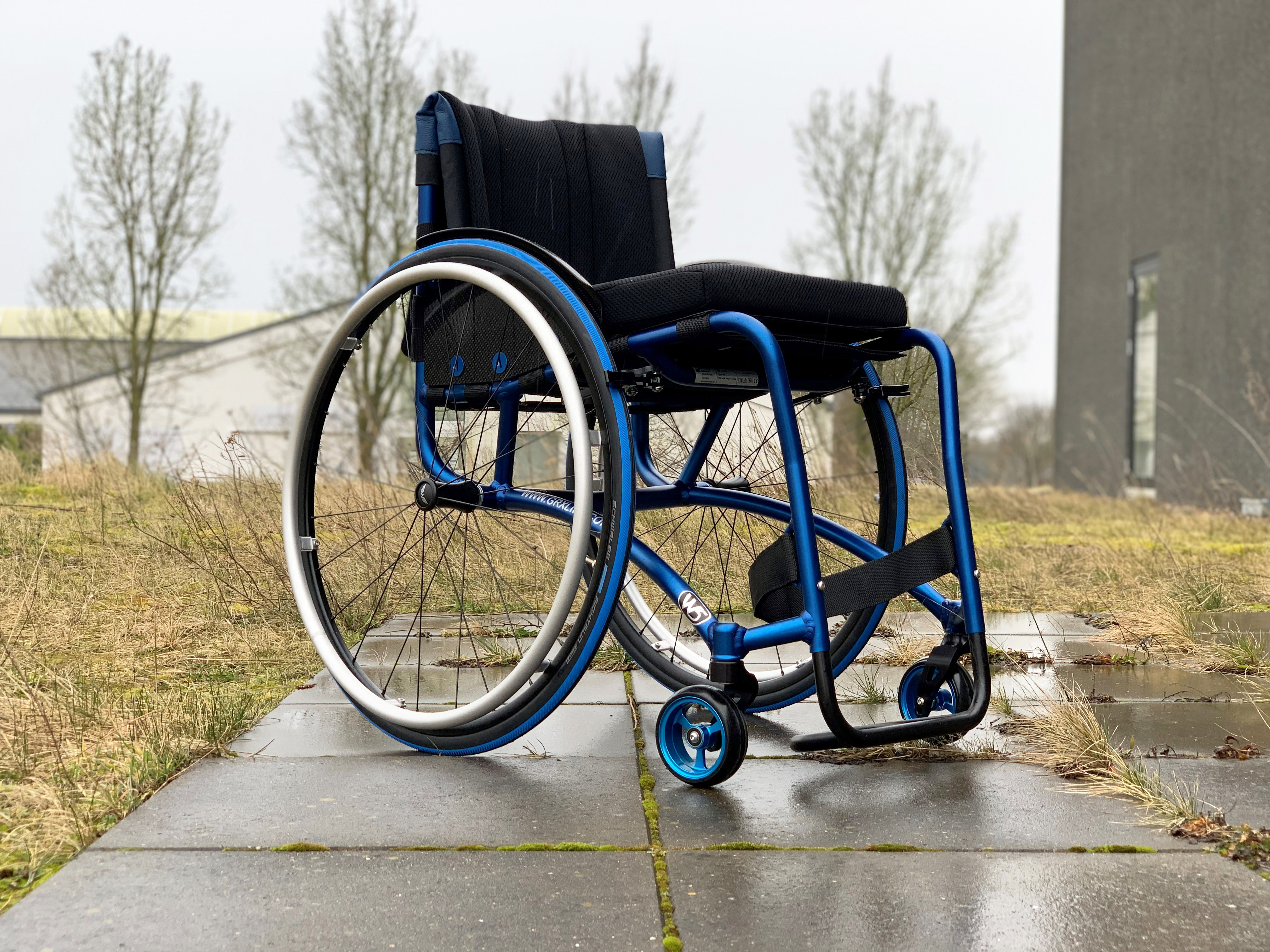 Wolturnus W5 SL in Blau eloxiert mit Schwalbe-Reifen und Lederdetails am Rücken im Freien