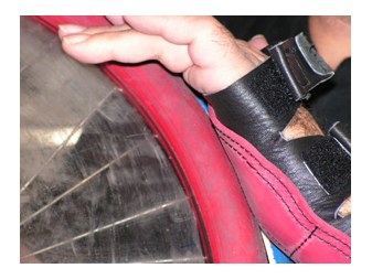 Roter Rugby-Gummi am Greifreifen, Hand mit Rugbyhandschuh