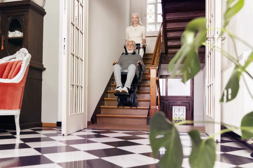 Person fährt mit dem Alber scalacombi S46 eine Treppe in einem Wohnhaus hinunter