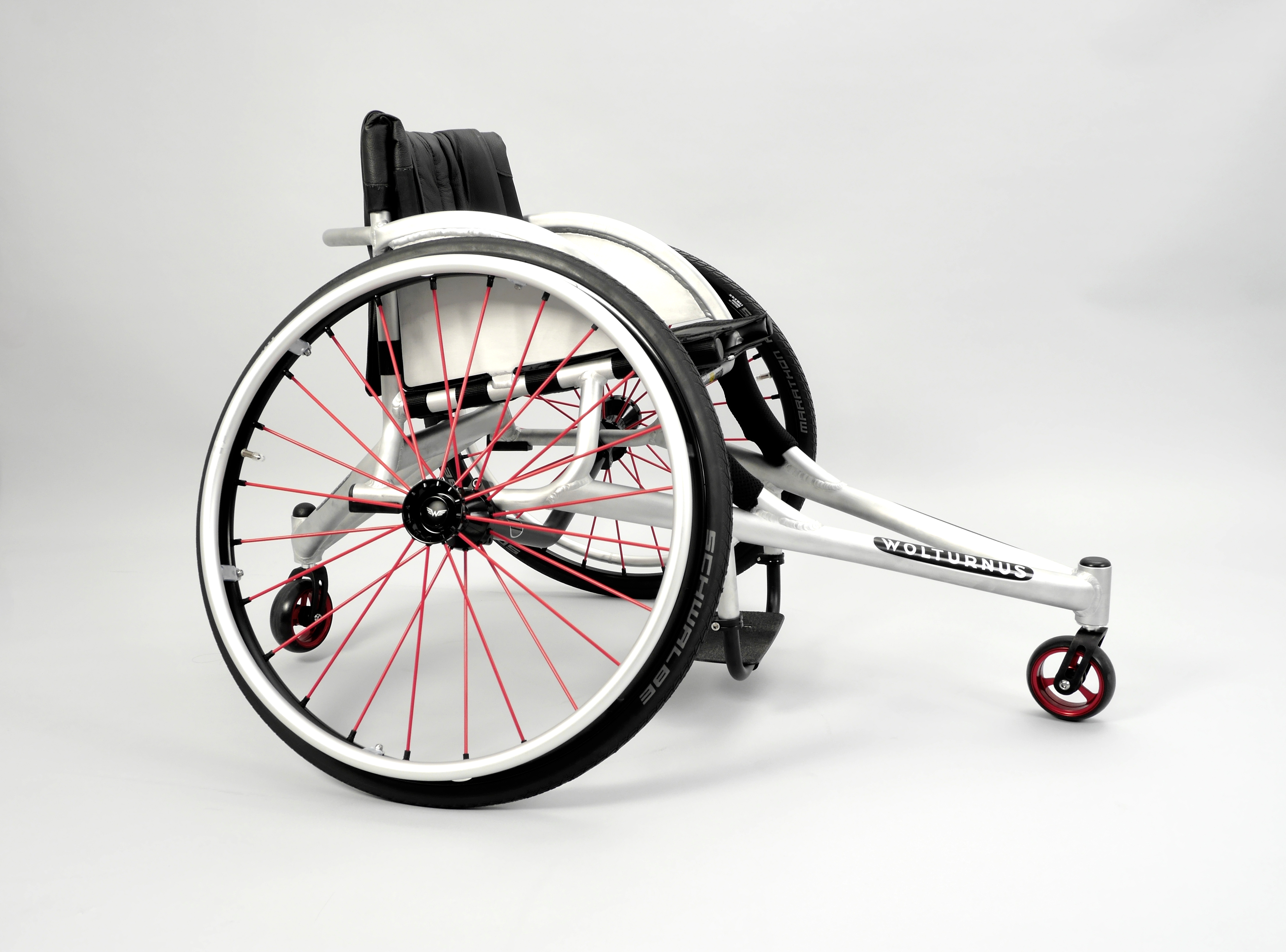 Wolturnus Tennisrollstuhl in Silber mit rot eingespeichten Rädern, Schrägansicht