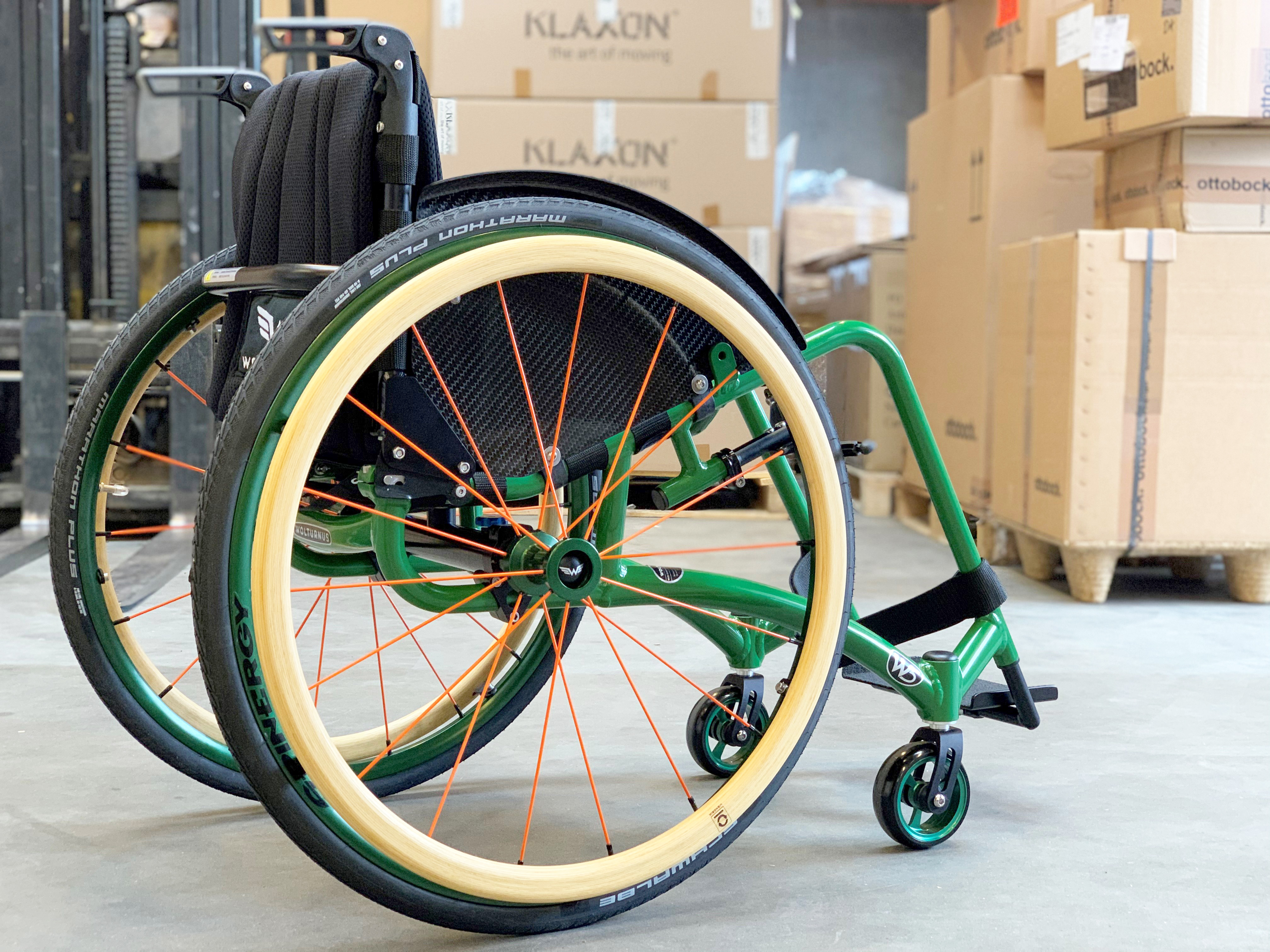 Wolturnus W5 S in Grün mit Spinergy-Rädern und hellen Reifen in einer Halle