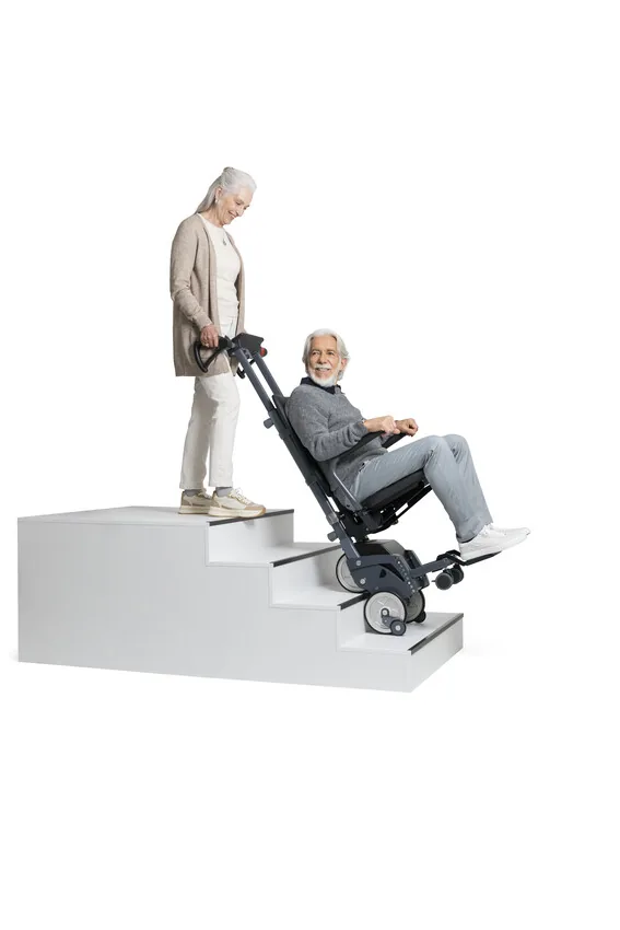 Begleitperson positioniert den Alber scalacombi S46 mit sitzender Person an einer Stufe