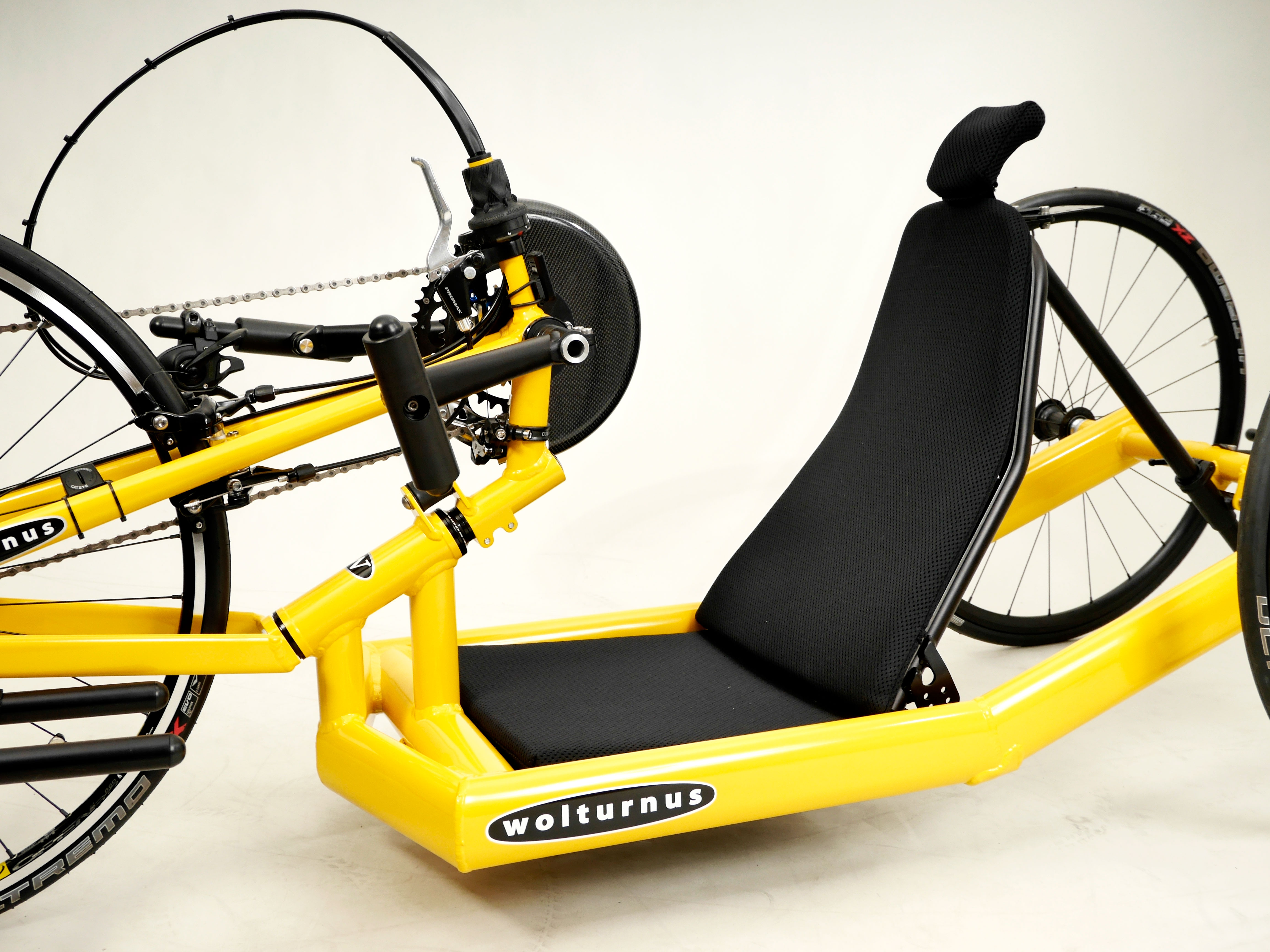 Wolturnus Antaras Handbike in Gelb mit Sitzschale und Kettenschaltung, Schrägansicht von vorn