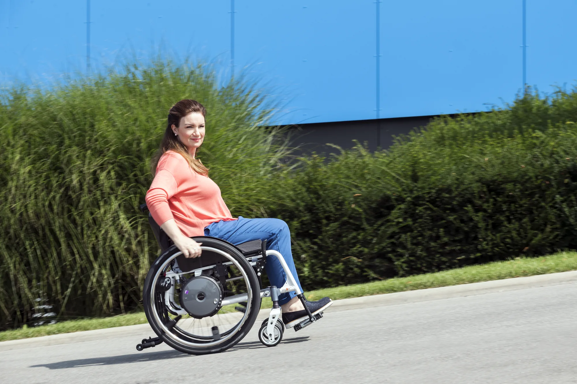 Rollstuhlfahrerin mit e-motion M25 auf einem Radweg