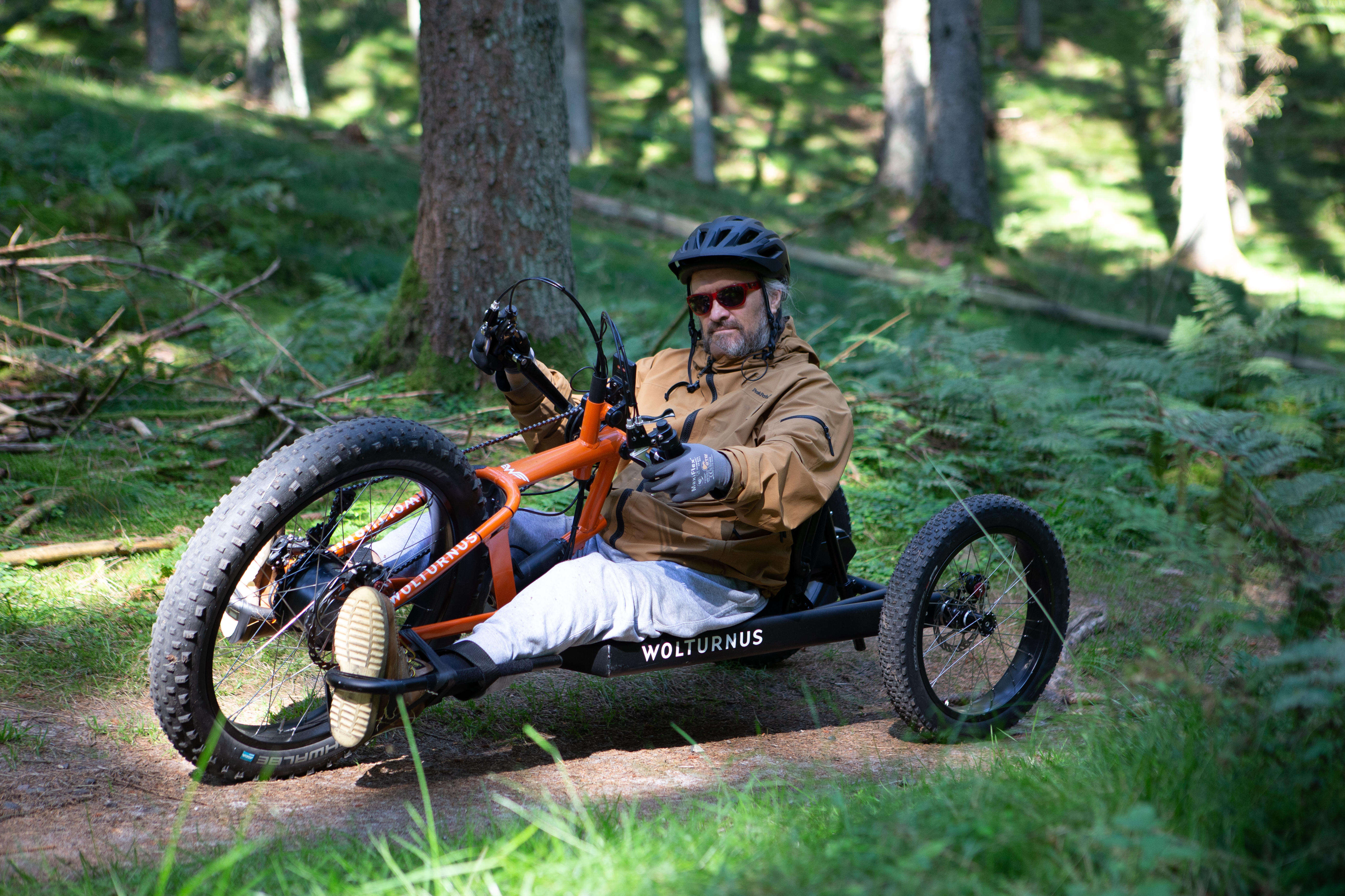 Fahrer mit Helm auf dem Wolturnus Fatbike im Wald, Blick auf die überbreiten Reifen