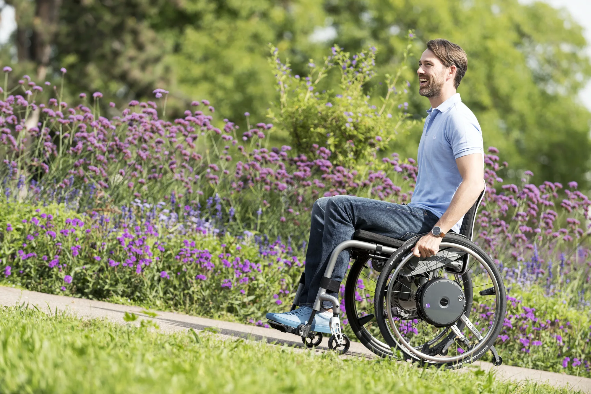 Rollstuhlfahrer fährt mit e-motion M25 auf einem Uferweg